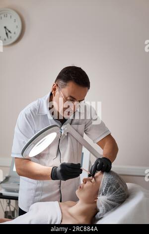 woman receives cosmetic botox injection in face. Stock Photo