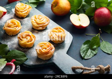 Apple Rose mini tarts with icing sugar on the stone cutting board. Stock Photo