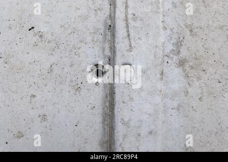 Mounting holes in the wall made of architectural concrete. Stock Photo