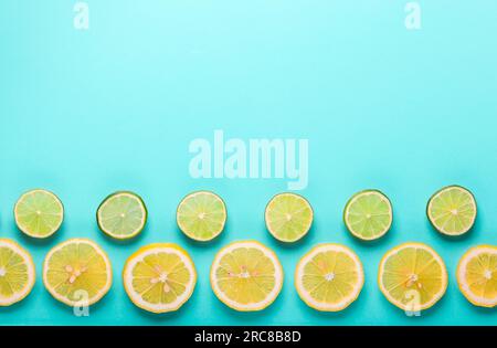 Slices of fresh lemon and lime pattern on pastel blue background in minimalist style. Flat lay, copy space. Stock Photo