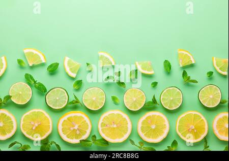 Slices of fresh lemon and lime pattern on pastel green background in minimalist style. Flat lay, copy space. Stock Photo