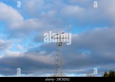 Tower with coastal surveillance radar system and various communication equipment. Cloudy blue sky background Stock Photo