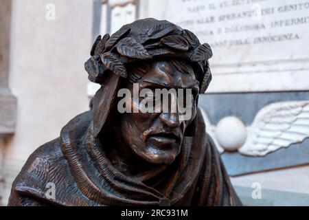 Florence, Italy - April 5, 2022: Bronze sculpture of Dante Alighieri, the legendary Italian poet in the courtyard of Badia Fiorentina, Florence, Italy Stock Photo