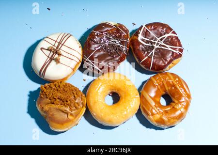 Delicious doughnuts on a light blue background, Rows of donuts pattern, variety of doughnuts Stock Photo