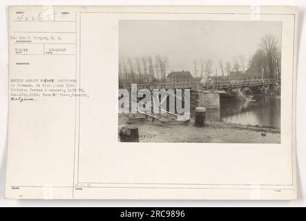 This photograph, labeled as 111-SC-42265, was taken by Lt. Ira H. Morgan of the Signal Corps on March 1, 1919. It shows the bridge across the Escaut River in Scheldt, Belgium, which was destroyed by the Germans during World War I. The photograph captures the 37th Division of the American military as they forced a crossing at this location on November 10, 1918, at 1:35 PM. The image is part of a collection of American military activities during the war. Stock Photo