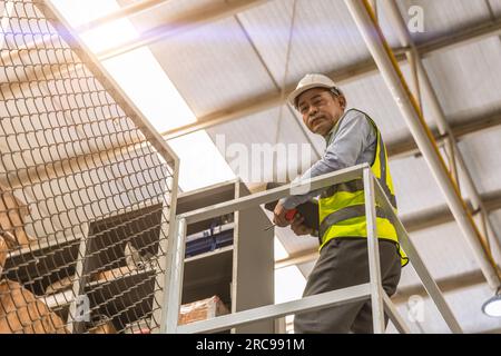 smart senior adult asian engineer male staff worker standing at high angle for success working people concept Stock Photo