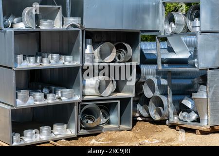 Various sheet metal air ducts in stock for installation in a building under construction. Ventilation system for large buildings. Ventilation pipes ma Stock Photo