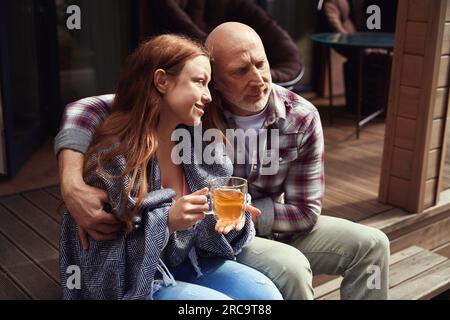 Romantic man is embracing happy lady on veranda Stock Photo