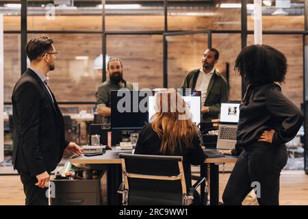 Colleagues and manager discussing over computer in office Stock Photo
