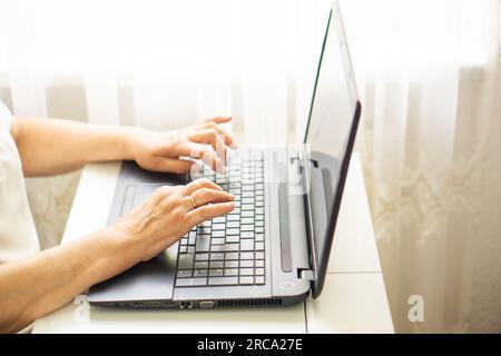 Close up of female hands typing on keyboard laptop. Business, education and programming concept. Stock Photo