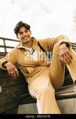 Portrait of happy young man wearing casuals while sitting on steps Stock Photo