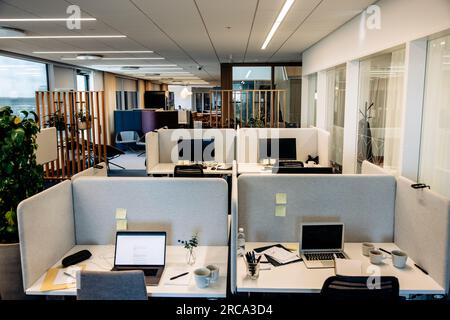 Empty tables with laptops in modern coworking office Stock Photo