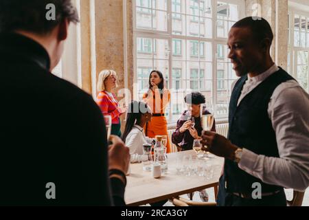 Male and female business colleagues having drinks during event at convention center Stock Photo