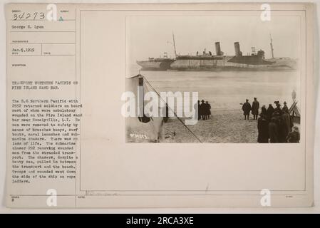 Photograph 34273 taken by George H. Lyon on January 6, 1919, shows the S.S. Northern Pacific on fire on Fire Island Sand Bar near Honelyville, L.I. The ship had 2552 returned soldiers on board, most of whom were ambulatory wounded. The men were safely rescued using breeches buoys, surf boats, naval launches, and submarine chasers. There were no casualties. The image also depicts submarine chaser 292 removing wounded soldiers from the stranded transport. The troops and wounded were brought down the side of the ship using rope ladders. Stock Photo