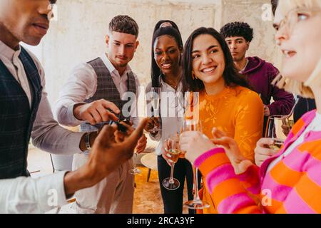 Smiling male and female business colleagues having fun during event at convention center Stock Photo