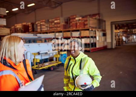 Cheerful multiracial female blue-collar workers in distribution warehouse Stock Photo