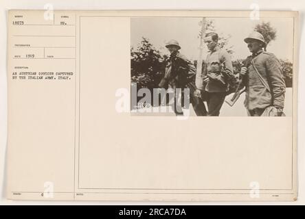 Image showing a captured Austrian officer being held by the Italian army during World War I in 1919. The officer is wearing an Austrian military uniform and is surrounded by Italian soldiers. This photograph was taken in Italy and is marked with the number 18073. Stock Photo