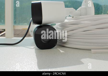 Detail of the security camera with a roll of wire, showing the importance of surveillance for everyone's protection and peace of mind. Stock Photo