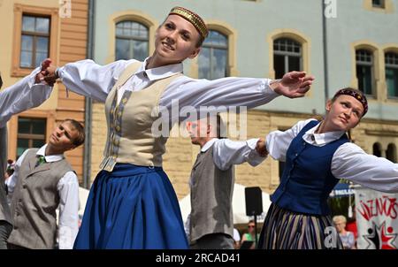 Gotha, Germany. 13th July, 2023. The children and youth dance group 'Viznits' from Latvia performs at the beginning of the 58th Europeade - European Folk Festival on Gotha's main market square. For the usually annual Europeade about 5000 participants from all over Europe meet in their traditional costumes at changing places. In addition to folk dances and a festive parade, the program includes a ball and an ecumenical church service. Credit: Martin Schutt/dpa/Alamy Live News Stock Photo