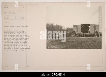 Caption: Mobile Laundry Unit No. 3 at Fort Washington, showing the front of the entire unit. In transit, the center floor and center roof are folded up, forming complete sides for the cars. The tractor pulls all four cars when moving between locations. The pipe from the tractor conveys hot water for washers in the trucks, and the belt connects the flywheel on the tractor to the wheel in the corner of the trucks, turning the washers inside. Photograph taken on May 3, 1919, by Sgt. Combs. Stock Photo