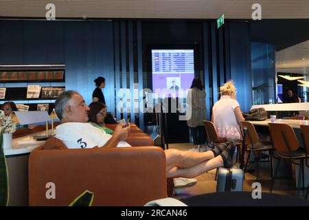 Athens Greece Athens International Airport (AIA) Eleftherios Venizelos Passengers Waiting in Executive Lounge with Electronic Departures Board Stock Photo