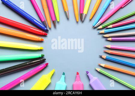 Frame made of colorful markers, pencils and pens on grey background Stock Photo