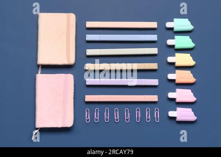 Stylish notebooks and markers in different shapes on blue background Stock Photo