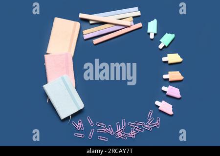 Frame made of stylish notebooks and markers in different shapes on blue background Stock Photo