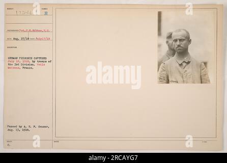 Image Caption: Group photograph of American soldiers posing with a captured German prisoner on July 16, 1918, in Veils Maisons, France. This photograph was taken by Pvt. J. E. Gibbon and received on August 27, 1918. It was issued and approved by the A. E. F. Censor on August 13, 1918. Stock Photo