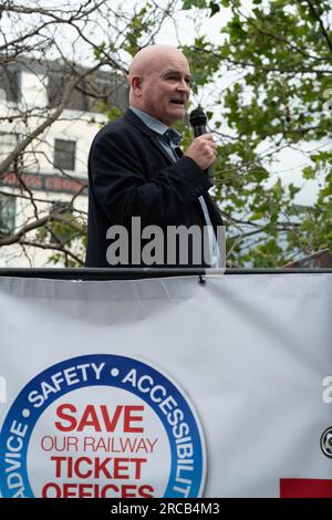 London, UK. 13 July, 2023. Mick Lynch, General Secretary of the Rail, Maritime and Transport Workers Union RMT) addresses a rally outside Kings Cross station as the train industry body the Rail Delivery Group (RDG) launch a consultation that could see nearly every train station ticket office in England close within three years. Campaigners opposing the plans, which also include disability and passenger groups, maintain closures are a cost cutting measure which would make the railway less safe, secure and accessible in addition to causing job cuts. Credit: Ron Fassbender/Alamy Live News Stock Photo