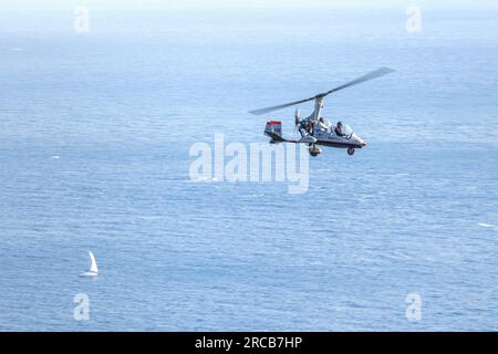 Taormina, Sicily, Italy - August 7, 2022 Leisure flight with Autogiro on the coast of Taormina in the Mediterranean Sea Stock Photo