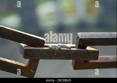 Two hands with wedding rings rest on a strong anchor chain. Stock Photo