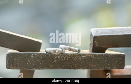 Two hands with wedding rings rest on a strong anchor chain. Stock Photo