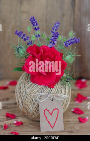 bouquet of red rose and lavender flowers in the ball of yarn as romantic decoration Stock Photo
