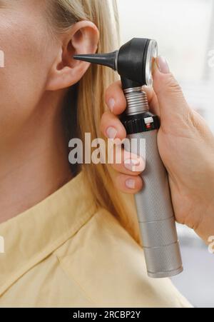 Woman patient having check-up of hearing at doctor otolaryngologist. Hearing exam for female. Otolaryngologist doctor checking mature woman's ear Stock Photo