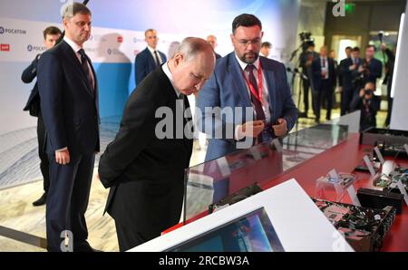 Moscow, Russia. 13th July, 2023. Russian President Vladimir Putin, center, and Russian Railways CEO Oleg Belozerov, left, listen to an exhibitor explain advanced research and development projects in quantum technologies during the Future Technologies Forum at the World Trade Center, July 13, 2023 in Moscow, Russia. Credit: Alexander Kazakov/Kremlin Pool/Alamy Live News Stock Photo