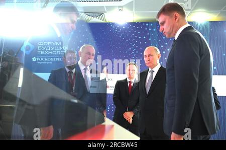 Moscow, Russia. 13th July, 2023. Russian President Vladimir Putin, center, and Russian Railways CEO Oleg Belozerov, right, listen to Quantum Center Co-founder Ruslan Yunusov, left, explain advanced research and development projects in quantum technologies during the Future Technologies Forum at the World Trade Center, July 13, 2023 in Moscow, Russia. Credit: Alexander Kazakov/Kremlin Pool/Alamy Live News Stock Photo