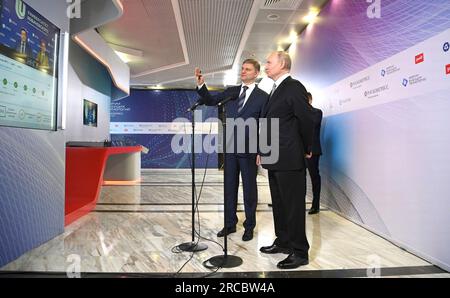 Moscow, Russia. 13th July, 2023. Russian President Vladimir Putin, right, listens to a Russian Railways CEO Oleg Belozerov, left, explain advanced research and development projects in quantum technologies during the Future Technologies Forum at the World Trade Center, July 13, 2023 in Moscow, Russia. Credit: Alexander Kazakov/Kremlin Pool/Alamy Live News Stock Photo