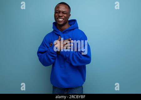 close-up of a laughing black american man in a sweatshirt with a hood on a studio background with copy space Stock Photo