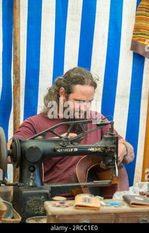 Craftman working with leather goods using an old singer sewing machine. Stock Photo