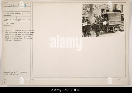 Lieutenant Estep of the American Red Cross, photographed Captain I. Newton distributing newspapers to soldiers at headquarters. This took place near Exermont, Ardennes, France on October 20, 1918. The soldiers belong to the 84th Infantry Brigade, 42nd Division. The photograph was issued and passed by the A.E.F. censor, date unknown. Stock Photo