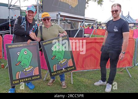 Winners of a charity auction pose with illustrated pub signs from The Petrol Head pop-up pub at Silverstone Woodlands camping during the F1 GP 2023 Stock Photo