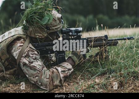 British Army officer cadets with the Royal Military Academy Sandhurst conduct a simulated assault during the academy exercise Dynamic Victory at Grafenwoehr Training Area, Germany, July 12, 2023. The exercise, and training in Germany, are part of the curriculum that lie between an officer cadet and their commissioning as an Army officer in the British Army. (U.S. Army photo by Spc. Christian Carrillo) Stock Photo