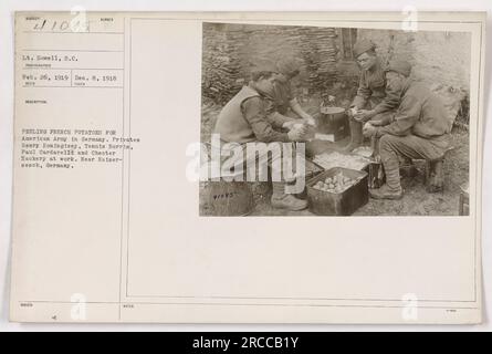 American soldiers peeling potatoes at a location near Kaiser- sesch, Germany. The soldiers in the image are Privates Henry Koningisey, Tennis Borris, Paul Cardarelli, and Chester Zackery. The photograph was taken by Lt. Dowell on Dec. 8, 1918. This image is from the series of Photographs of American Military Activities during World War One. Stock Photo