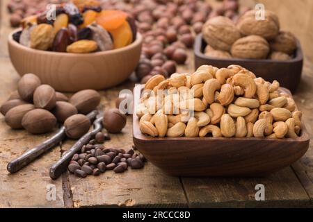 cashew nuts peeled roasted in bowl on wood table. Useful food stuffs for vegetarian and vegan. Stock Photo