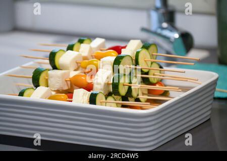 Skewers of Halloumi and vegetables before grilling Halloumi or haloumi is a cheese made from a mixture of goat's and sheep's milk, and sometimes also Stock Photo
