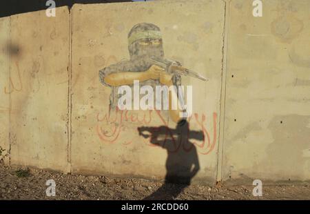 A painted wall depicting a Palestinian gunman sits on display at a ...