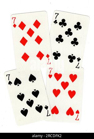 Vintage playing cards showing four sevens on a white background. Stock Photo