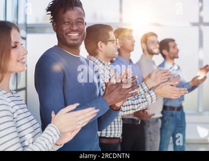 Stand out presentations get standing ovations. Diverse group of business people smiling and clapping with a standing ovation at a conference Stock Photo