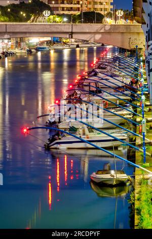 Small fishing boats docked in the Pescara river at night, Pescara, Italy Stock Photo